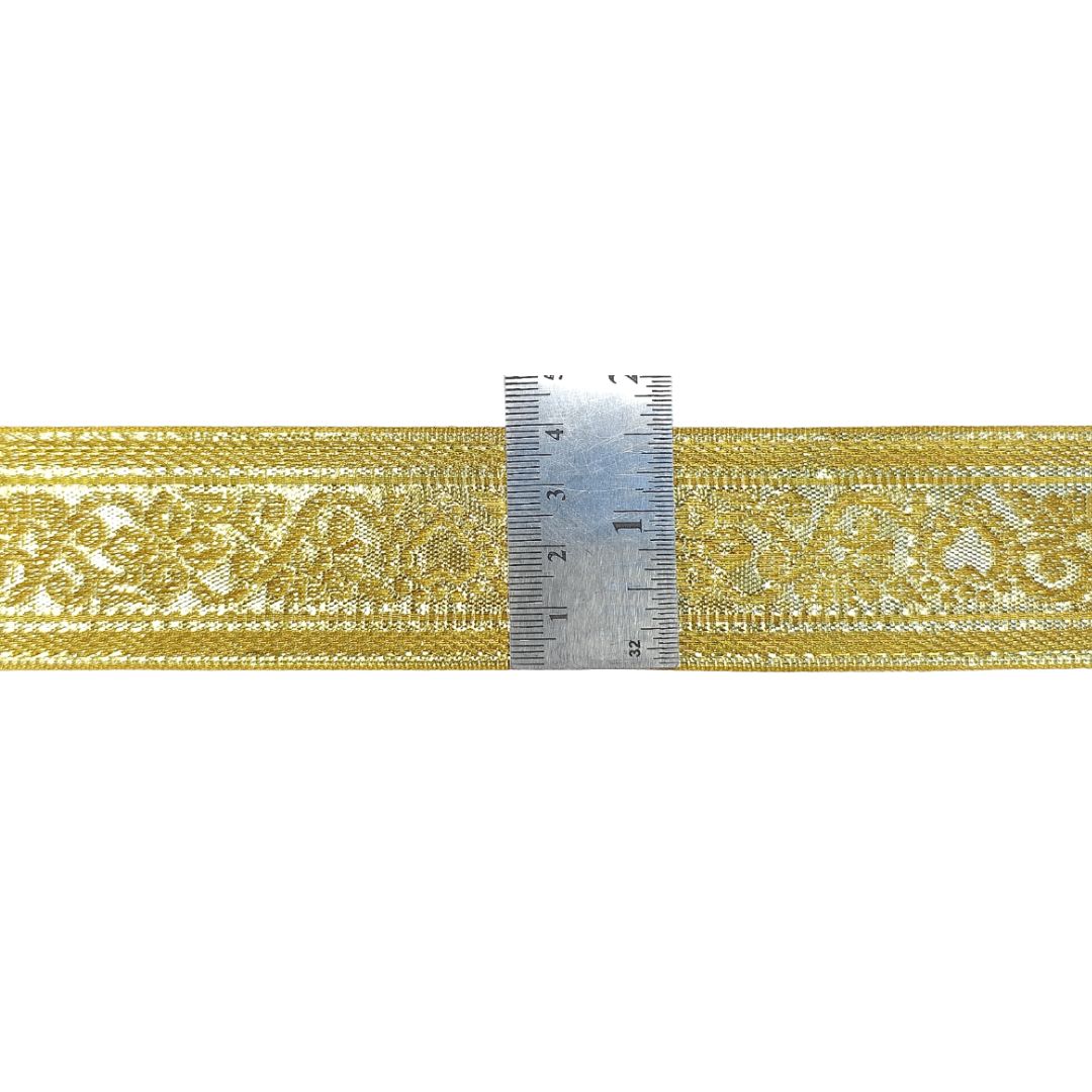 Gold lace ribbon with a ruler for measurement on a white background